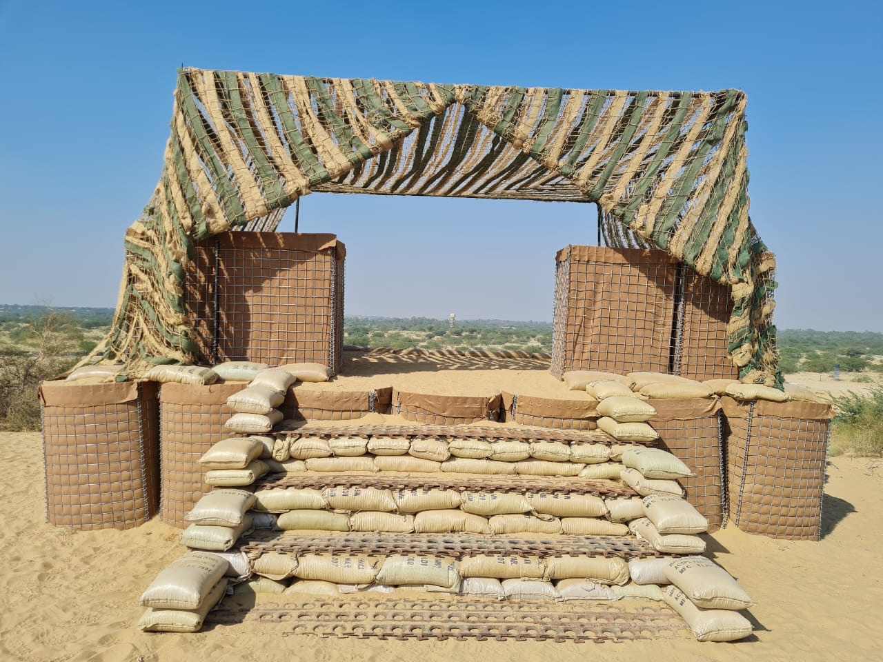 Filled welded-wire barrier cells incorporated into a protective field position